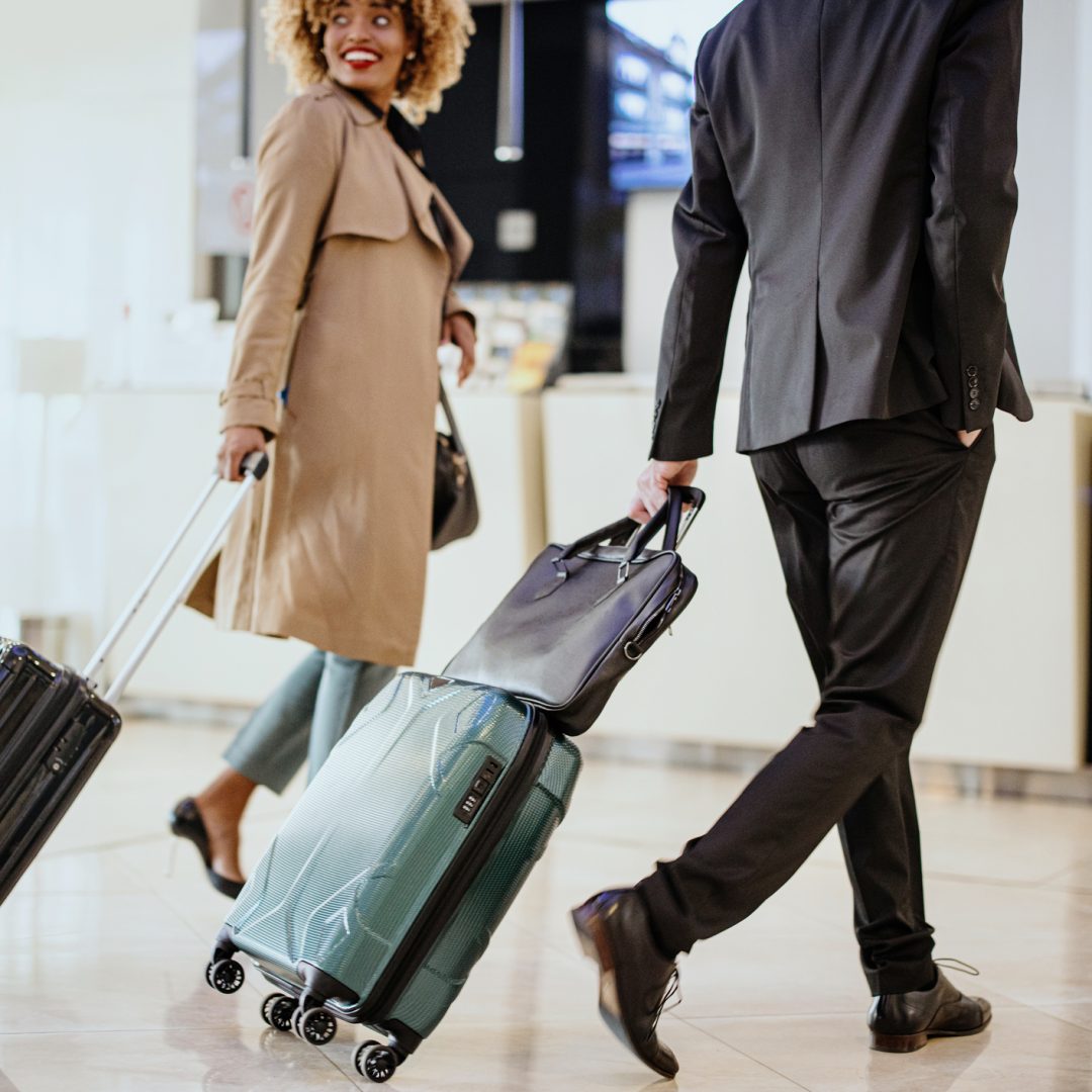 Business travellers with suitcases walking towards reception